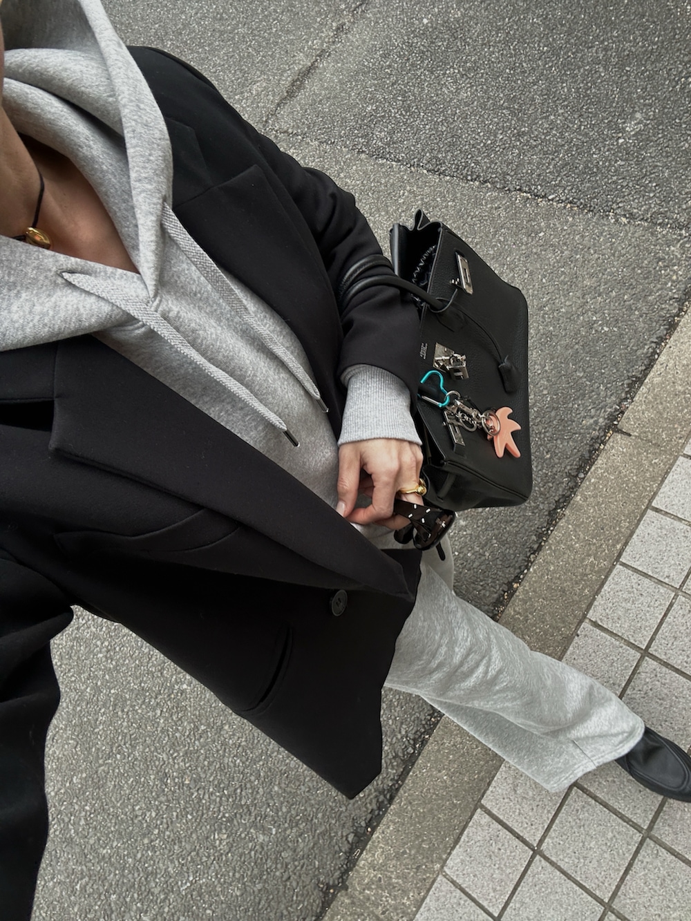 グレー系のスウェットパンツ、ブラック系のモカシン/デッキシューズ、ブラック系のバッグを着用したレディースの春コーディネートの3枚目の写真