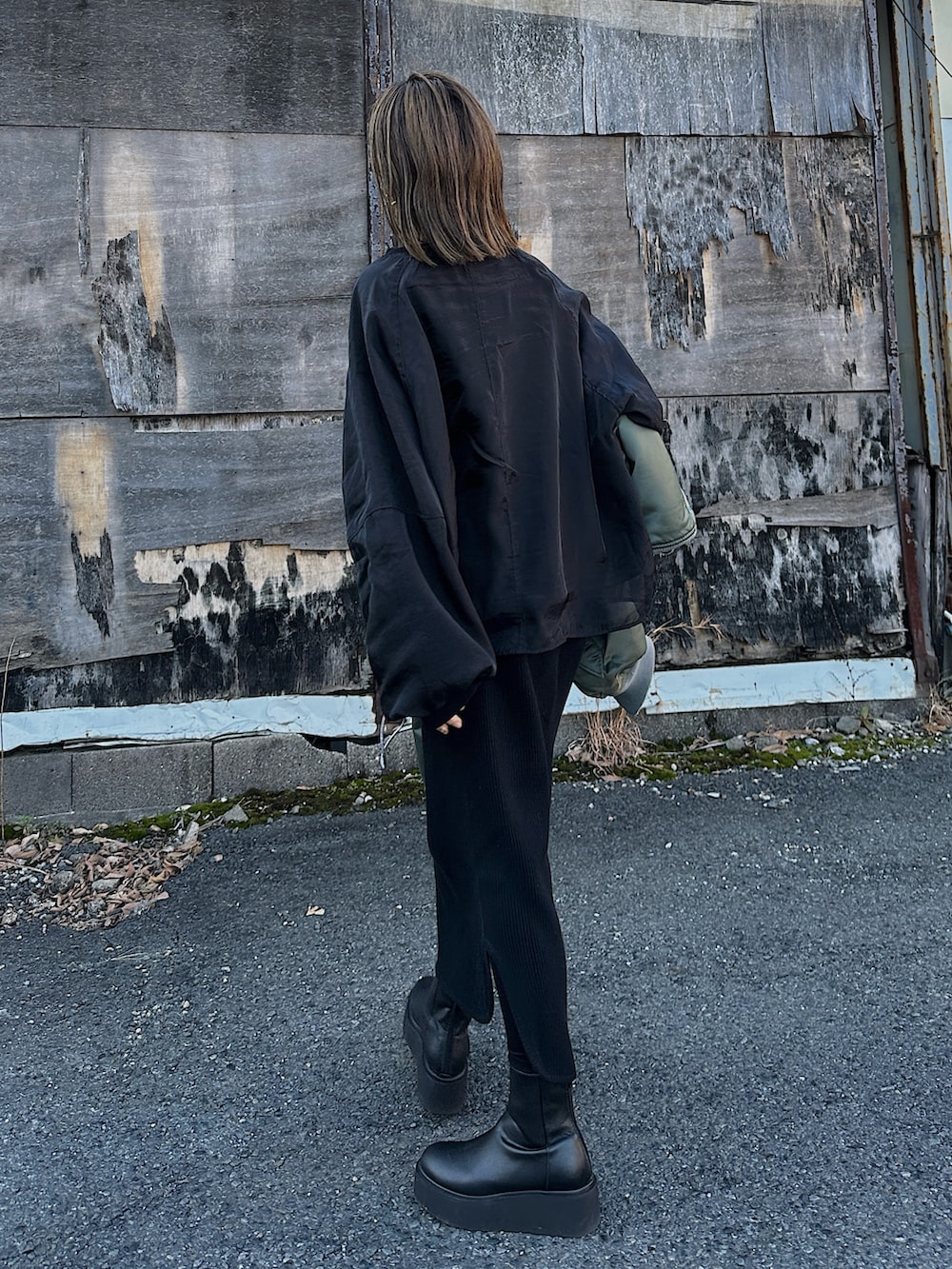 グリーン系のMA-1、シルバー系のバッグ、ブラック系のブーツを着用したレディースの冬コーディネートの5枚目の写真