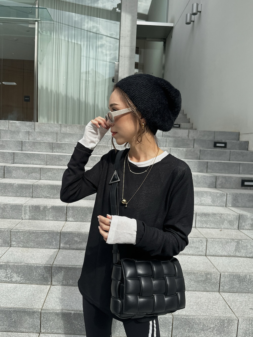 ブラック系のスニーカー、ブラック系のショルダーバッグ、ブラック系のその他パンツを着用したレディースの秋コーディネートの4枚目の写真