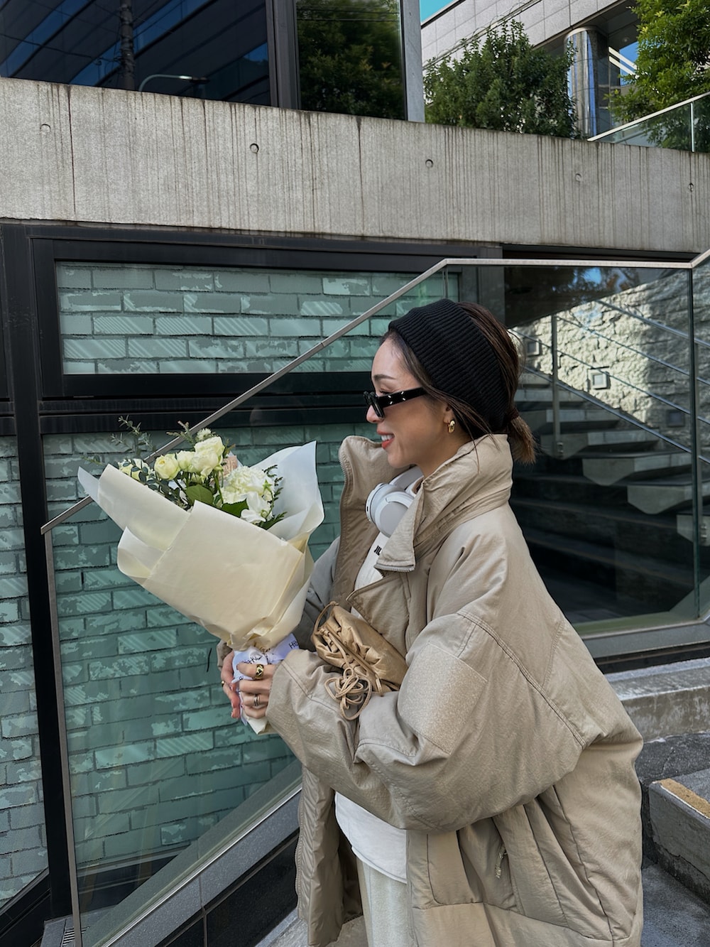 グリーン系のダウンジャケット/コート、ホワイト系のスウェット、ベージュ系のバッグを着用したレディースの冬コーディネートの3枚目の写真