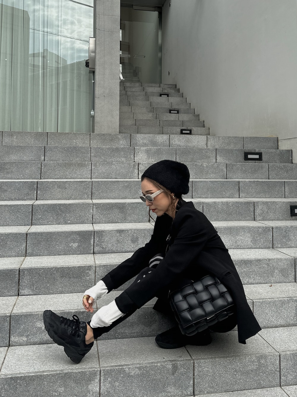 ブラック系のスニーカー、ブラック系のショルダーバッグ、ブラック系のその他パンツを着用したレディースの秋コーディネートの3枚目の写真