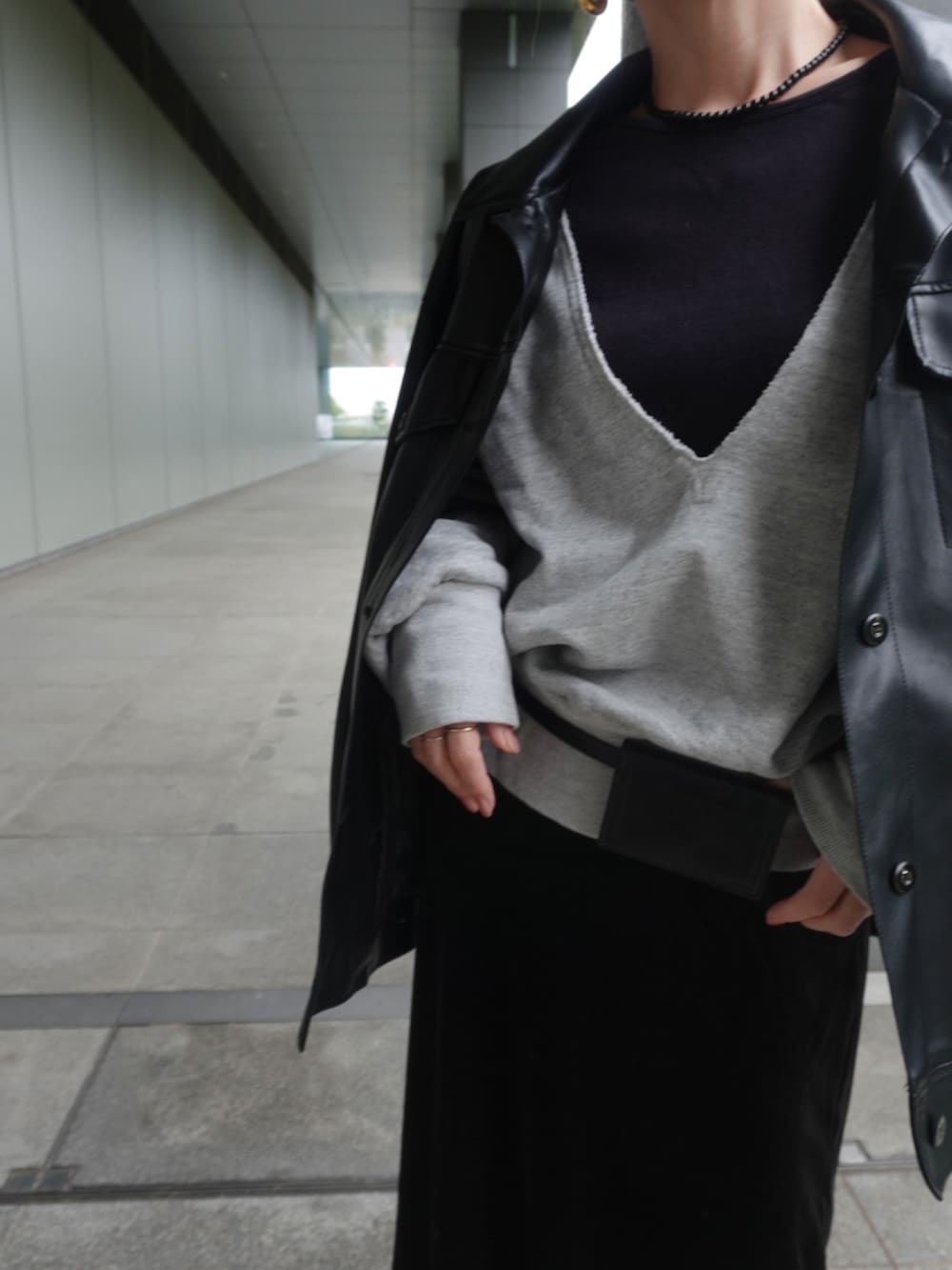 ブラック系のライダースジャケット、ブラック系のスカート、ブラック系のスリッポンを着用したレディースの冬コーディネートの2枚目の写真