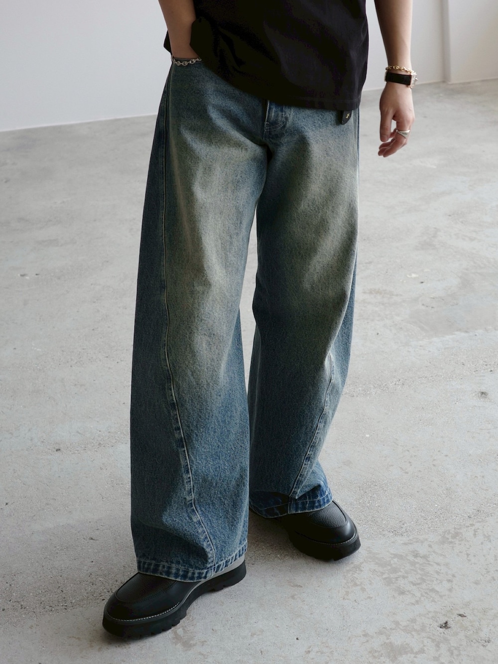 ブラック系のTシャツ/カットソー、ブルー系のデニムパンツ、ブラック系のドレスシューズを着用したメンズの春コーディネートの4枚目の写真