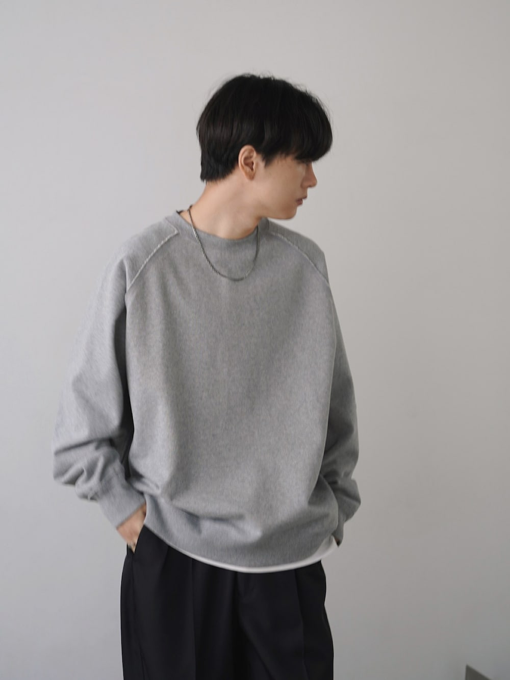 グレー系のスウェット、ホワイト系のシャツ/ブラウス、グリーン系のカーゴパンツを着用したメンズの冬コーディネートの3枚目の写真