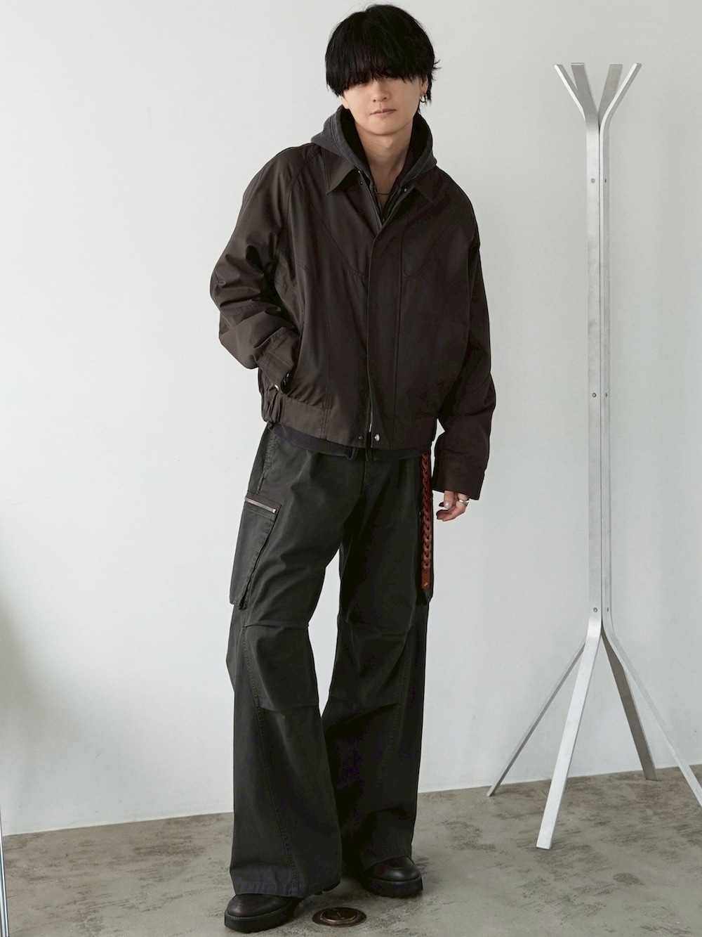 ブラウン系のブルゾン、ブラウン系のパーカー、ブラウン系のカーゴパンツを着用したメンズの春コーディネートの3枚目の写真