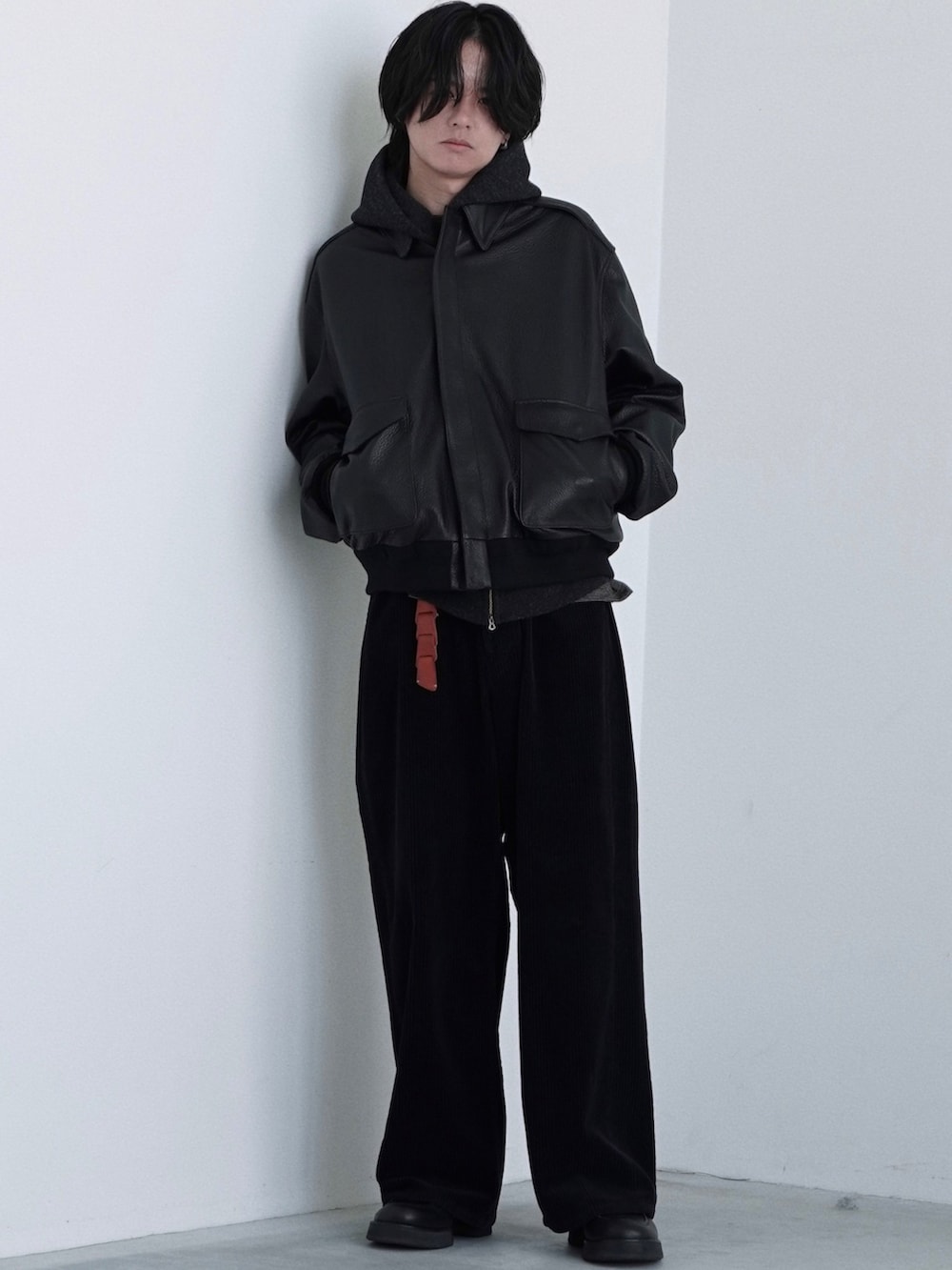 ブラック系のブルゾン、ブラック系のパーカー、イエロー系のTシャツ/カットソーを着用したメンズの秋コーディネートの2枚目の写真