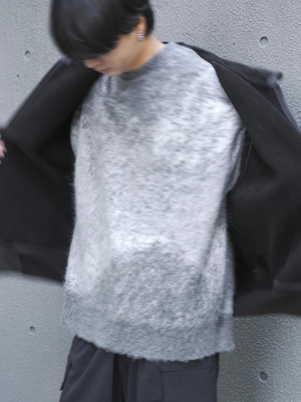 グレー系のニット/セーター、ブラック系のブーツ、シルバー系のピアス(片耳用)を着用したメンズの冬コーディネートの5枚目の写真