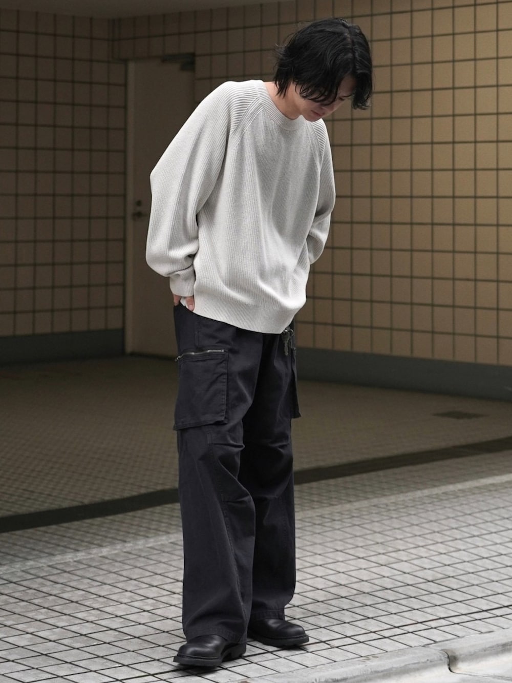 ホワイト系のニット/セーター、ブラック系のカーゴパンツ、グレー系のブルゾンを着用したメンズの秋コーディネートの5枚目の写真