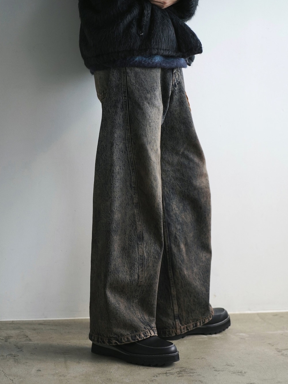 グレー系のブルゾン、ブルー系のニット/セーター、ブルー系のデニムパンツを着用したメンズの冬コーディネートの5枚目の写真