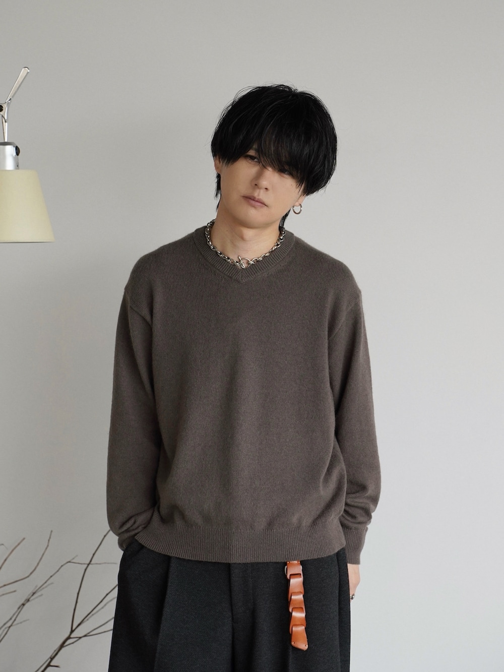ブラック系のドレスシューズ、ブラウン系のニット/セーター、グレー系のスラックスを着用したメンズの秋コーディネートの2枚目の写真