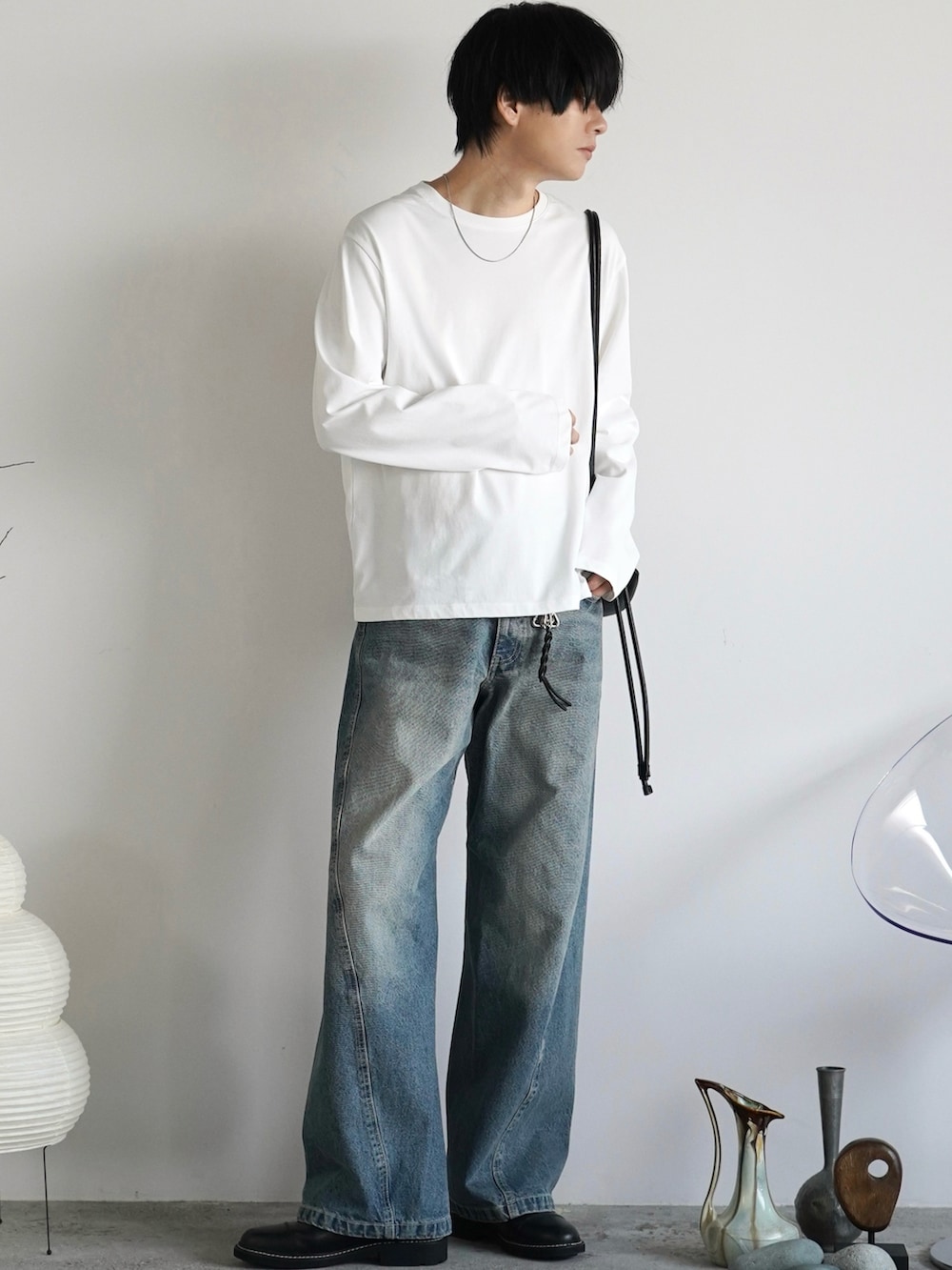 ブルー系のデニムパンツ、ホワイト系のTシャツ/カットソー、ブラック系のショルダーバッグを着用したメンズの秋コーディネートの2枚目の写真