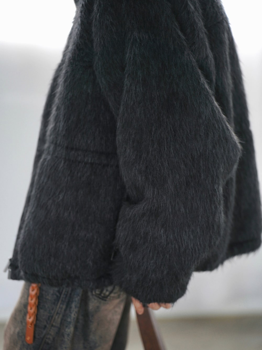 グレー系のブルゾン、ブルー系のニット/セーター、ブルー系のデニムパンツを着用したメンズの冬コーディネートの4枚目の写真