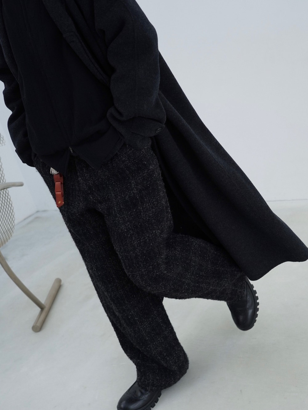 ブラック系のチェスターコート、ブラック系のニット/セーター、ブラック系のその他パンツを着用したメンズの秋コーディネートの3枚目の写真