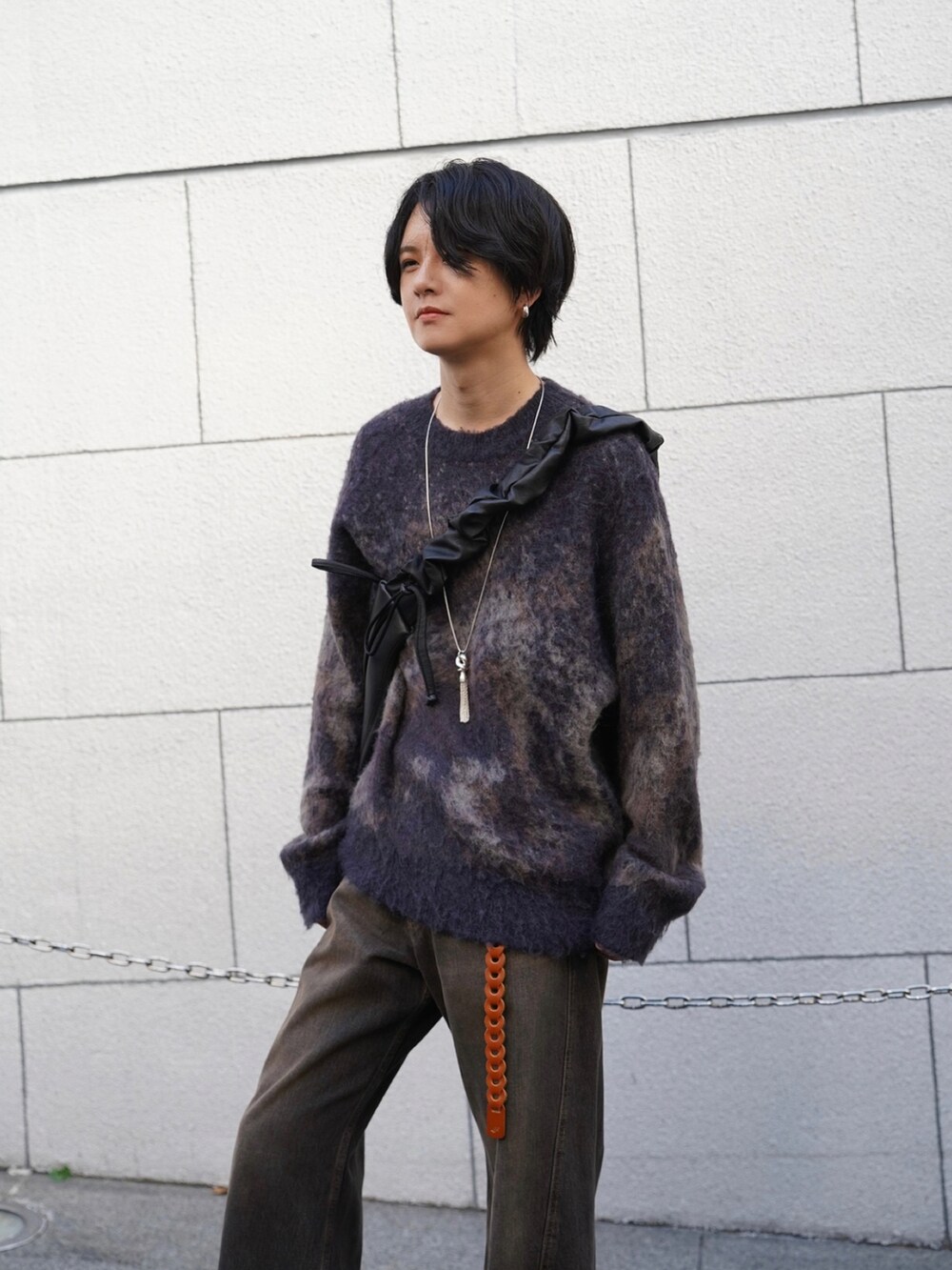 ブラウン系のニット/セーター、ブラック系のデニムパンツ、ブラック系のショルダーバッグを着用したメンズの秋コーディネートの4枚目の写真
