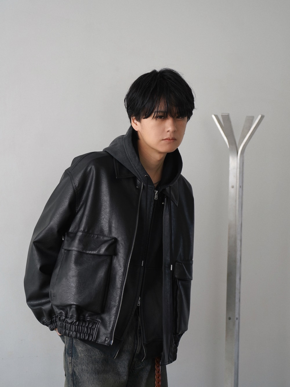 ブラック系のブルゾン、ブラック系のドレスシューズ、ブラック系のパーカーを着用したメンズの冬コーディネートの2枚目の写真