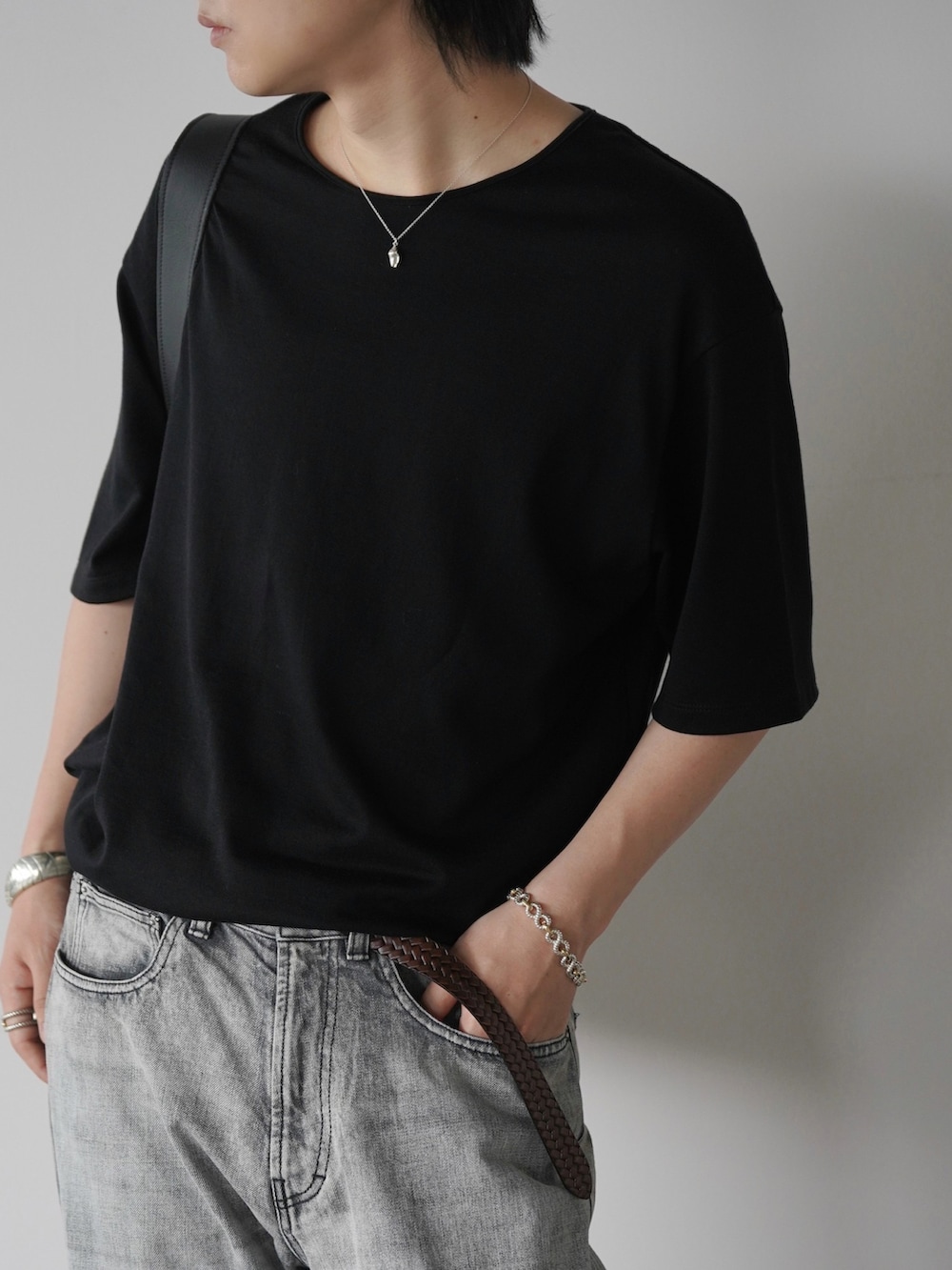 ブラック系のTシャツ/カットソー、グレー系のデニムパンツ、ブラック系のブーツを着用したメンズの夏コーディネートの2枚目の写真