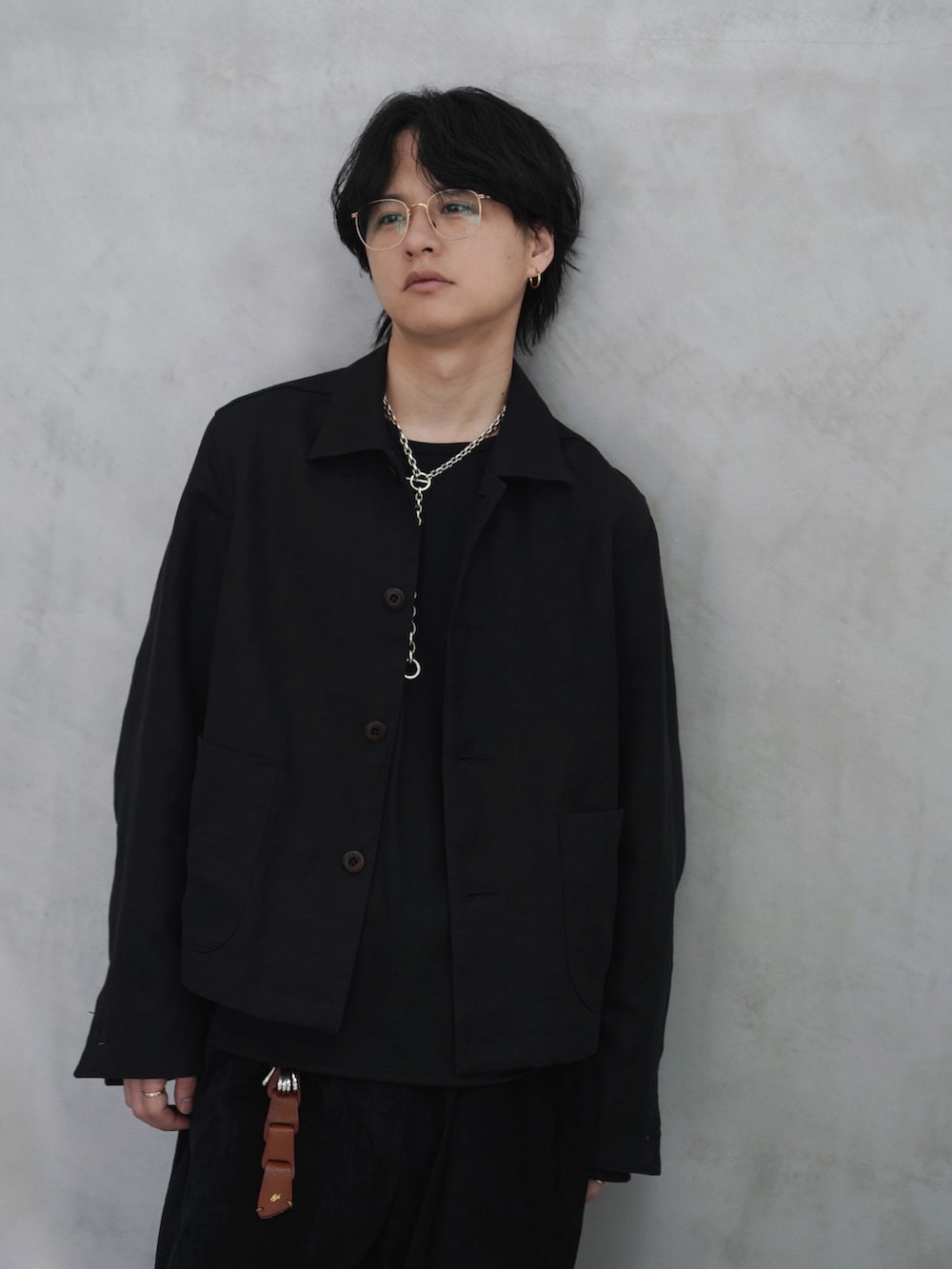 ブラック系のステンカラーコート、ブラック系のブルゾン、ブラック系のスラックスを着用したメンズの春コーディネートの3枚目の写真