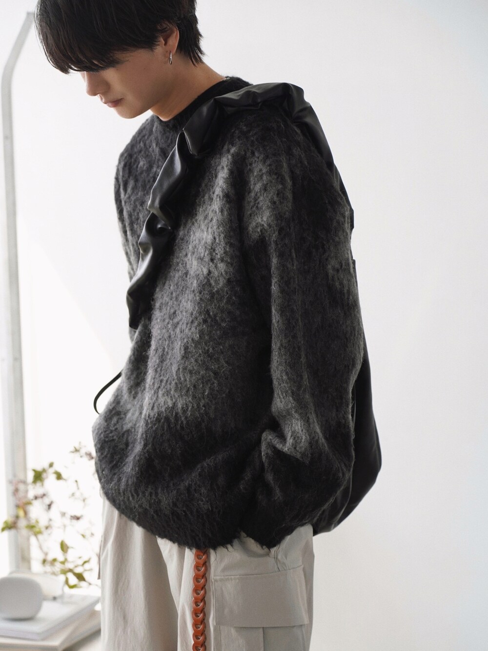 グレー系のベスト、グレー系のニット/セーター、グレー系のカーゴパンツを着用したメンズの春コーディネートの3枚目の写真