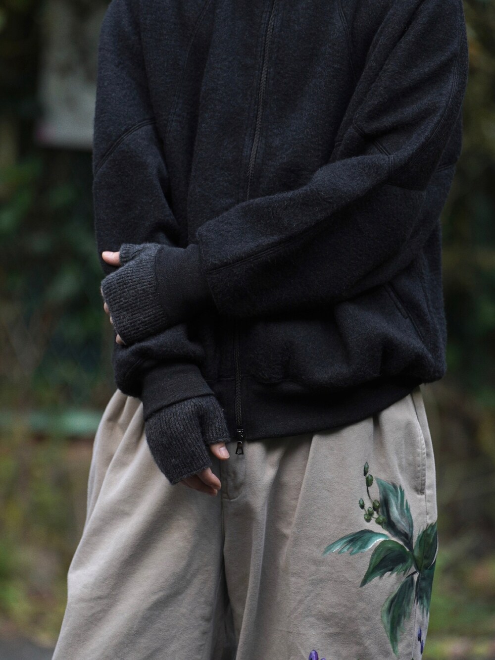 ブラック系のチェスターコート、ブラック系のトップス、グレー系のパンツを着用したメンズの秋コーディネートの4枚目の写真