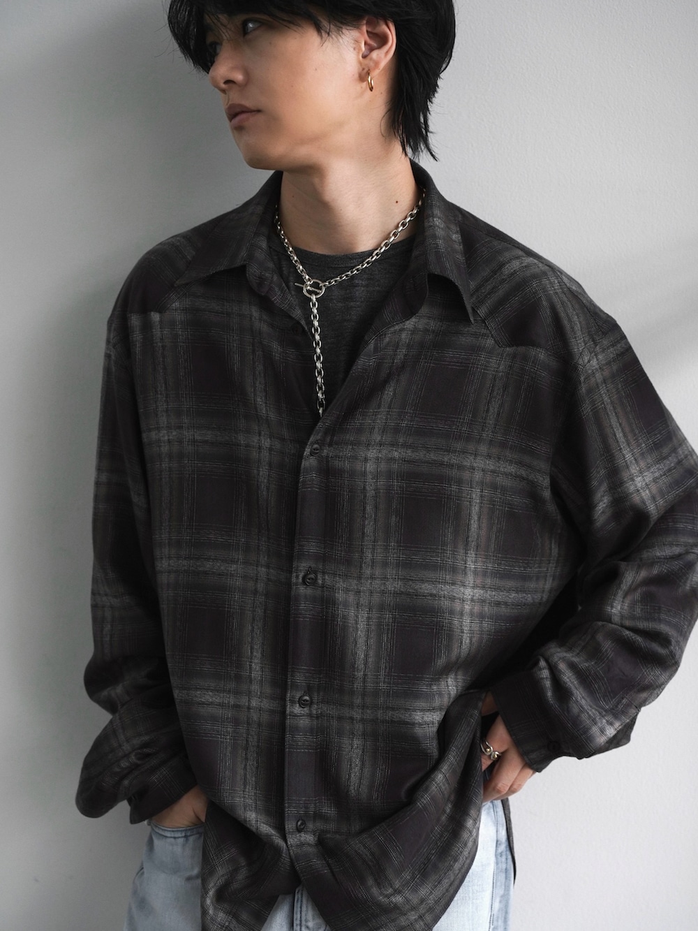 グレー系のチェスターコート、ブラック系のブーツ、ブラウン系のシャツ/ブラウスを着用したメンズの春コーディネートの3枚目の写真