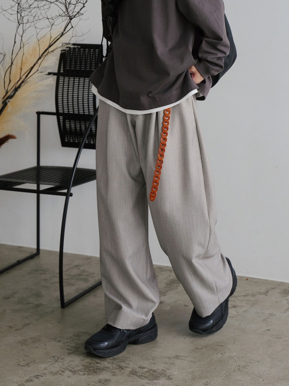 ブラウン系のTシャツ/カットソー、ホワイト系のタンクトップ、グレー系のスラックスを着用したメンズの夏コーディネートの3枚目の写真