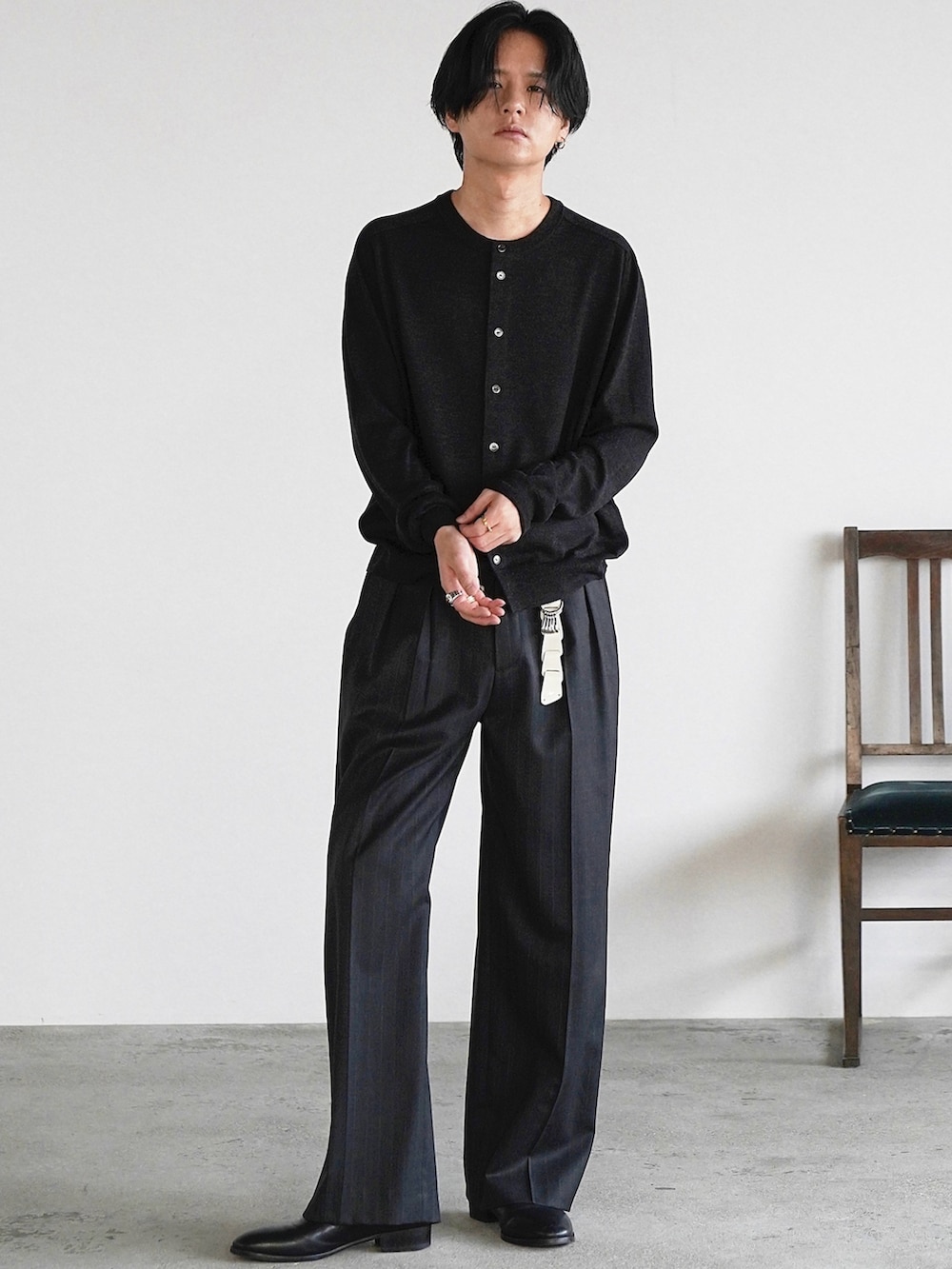 グレー系のスラックス、ブラック系のブーツ、ブラック系のニット/セーターを着用したメンズの冬コーディネートの3枚目の写真