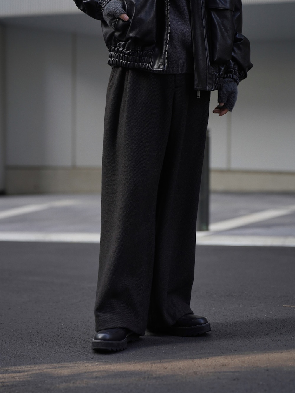 ブラック系のブルゾン、グレー系のスラックス、ブラック系のドレスシューズを着用したメンズの秋コーディネートの5枚目の写真