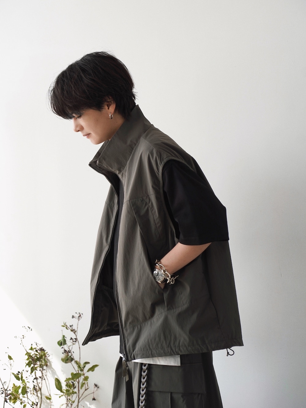 グレー系のベスト、ブラック系のTシャツ/カットソー、ホワイト系のタンクトップを着用したメンズの春コーディネートの4枚目の写真