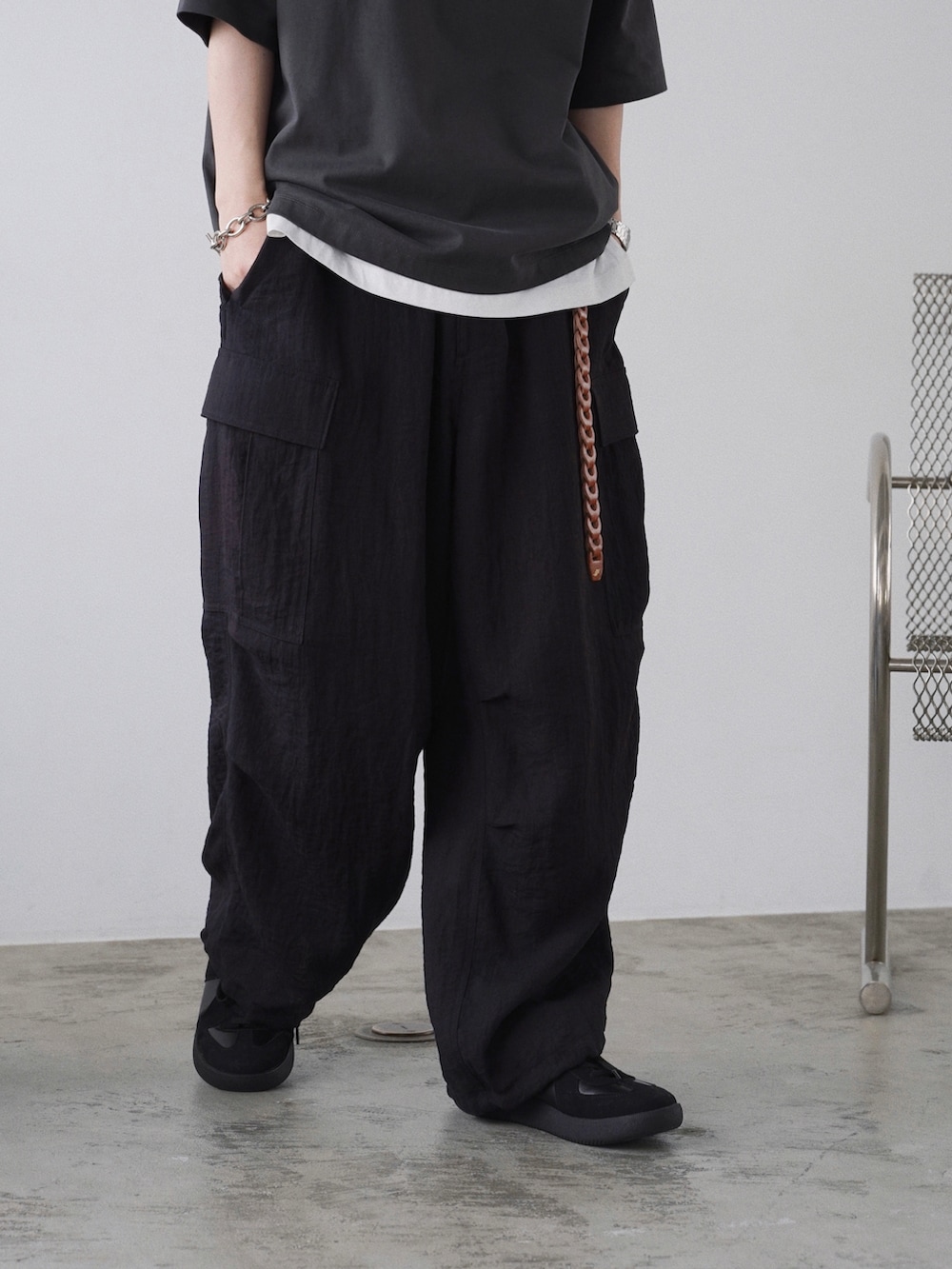 グレー系のTシャツ/カットソー、ホワイト系のタンクトップ、ブラック系のカーゴパンツを着用したメンズの春コーディネートの3枚目の写真