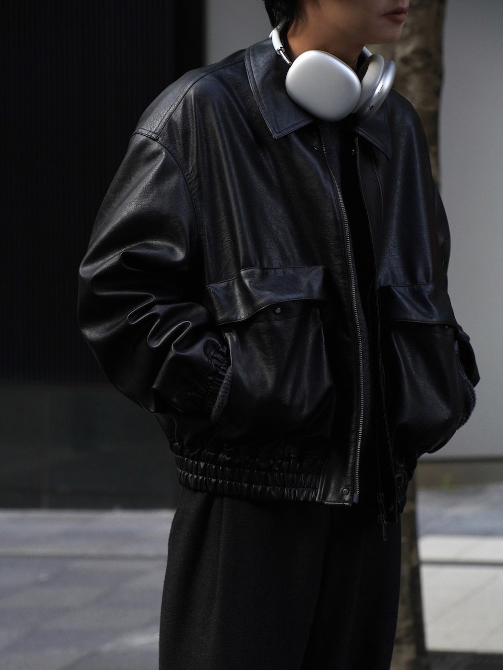 ブラック系のブルゾン、グレー系のスラックス、ブラック系のドレスシューズを着用したメンズの秋コーディネートの3枚目の写真