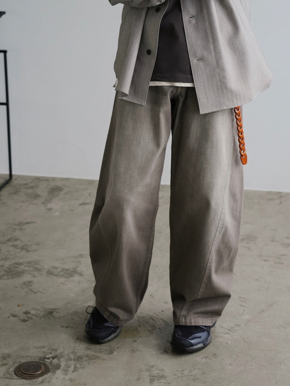 ブラウン系のTシャツ/カットソー、ブラウン系のデニムパンツ、シルバー系のピアス（片耳用）を着用したメンズの夏コーディネートの3枚目の写真