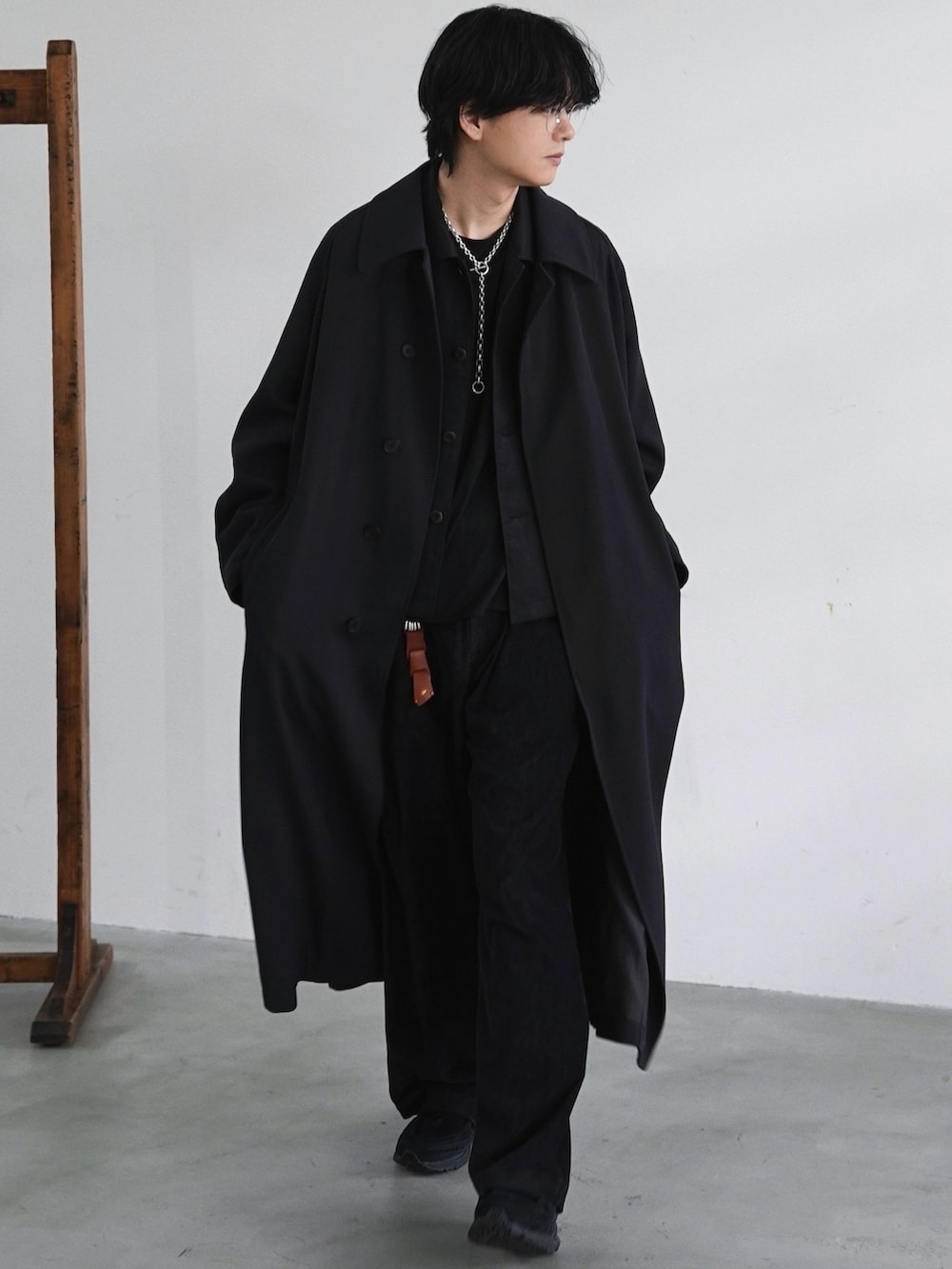 ブラック系のステンカラーコート、ブラック系のブルゾン、ブラック系のスラックスを着用したメンズの春コーディネートの2枚目の写真