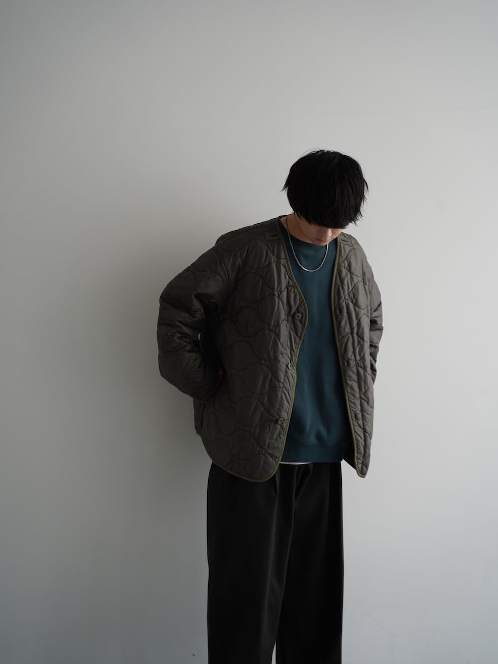 グリーン系のモッズコート、グリーン系のスウェット、ホワイト系のタンクトップを着用したメンズの秋コーディネートの2枚目の写真