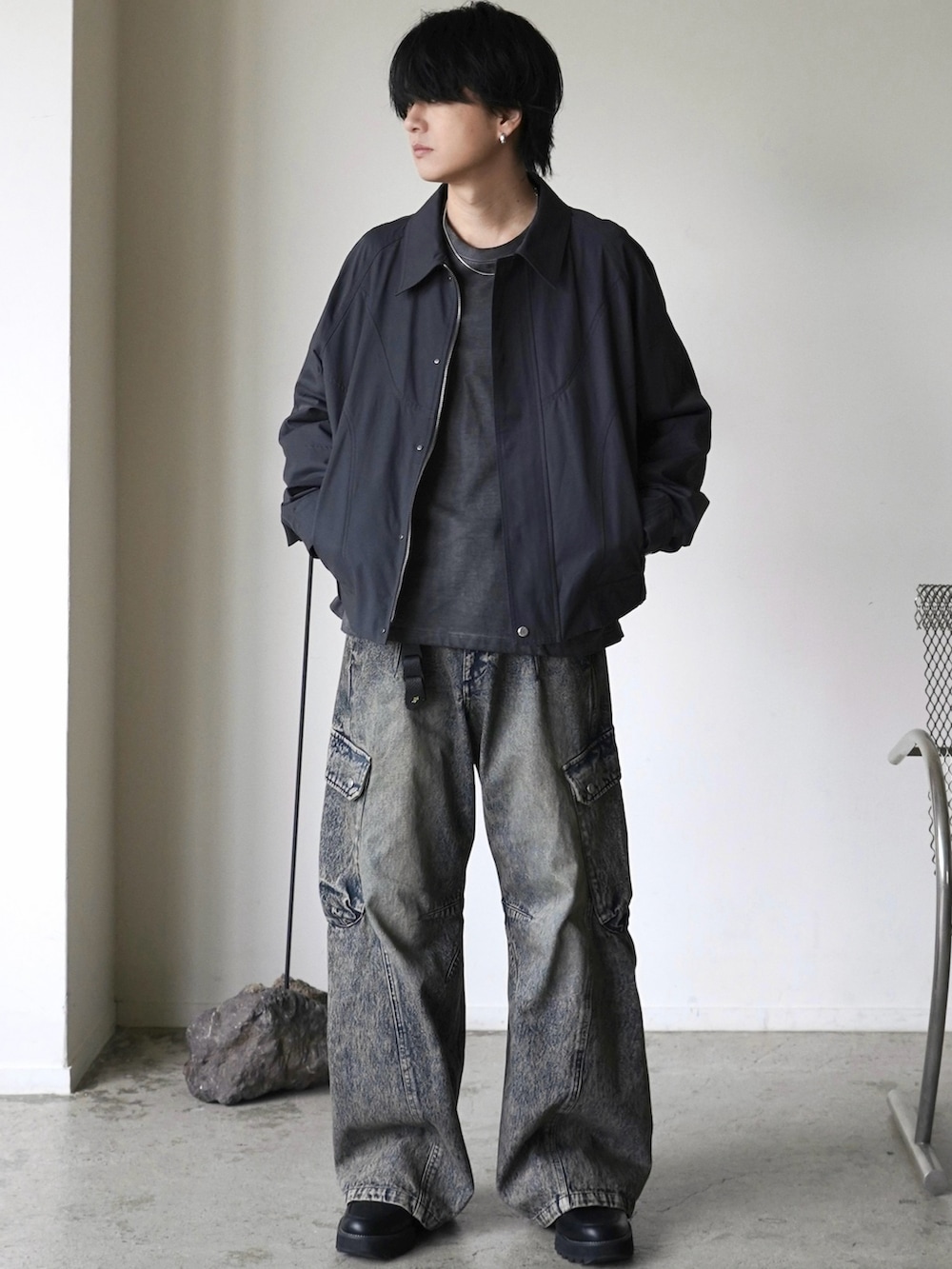 グレー系のブルゾン、グレー系のTシャツ/カットソー、ブルー系のデニムパンツを着用したメンズの春コーディネートの2枚目の写真