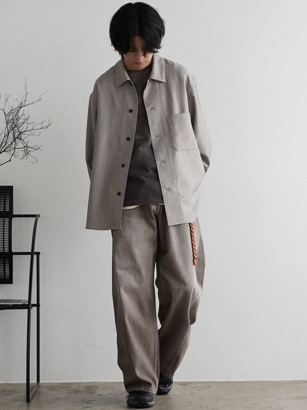 ブラウン系のTシャツ/カットソー、ブラウン系のデニムパンツ、シルバー系のピアス（片耳用）を着用したメンズの夏コーディネートの2枚目の写真