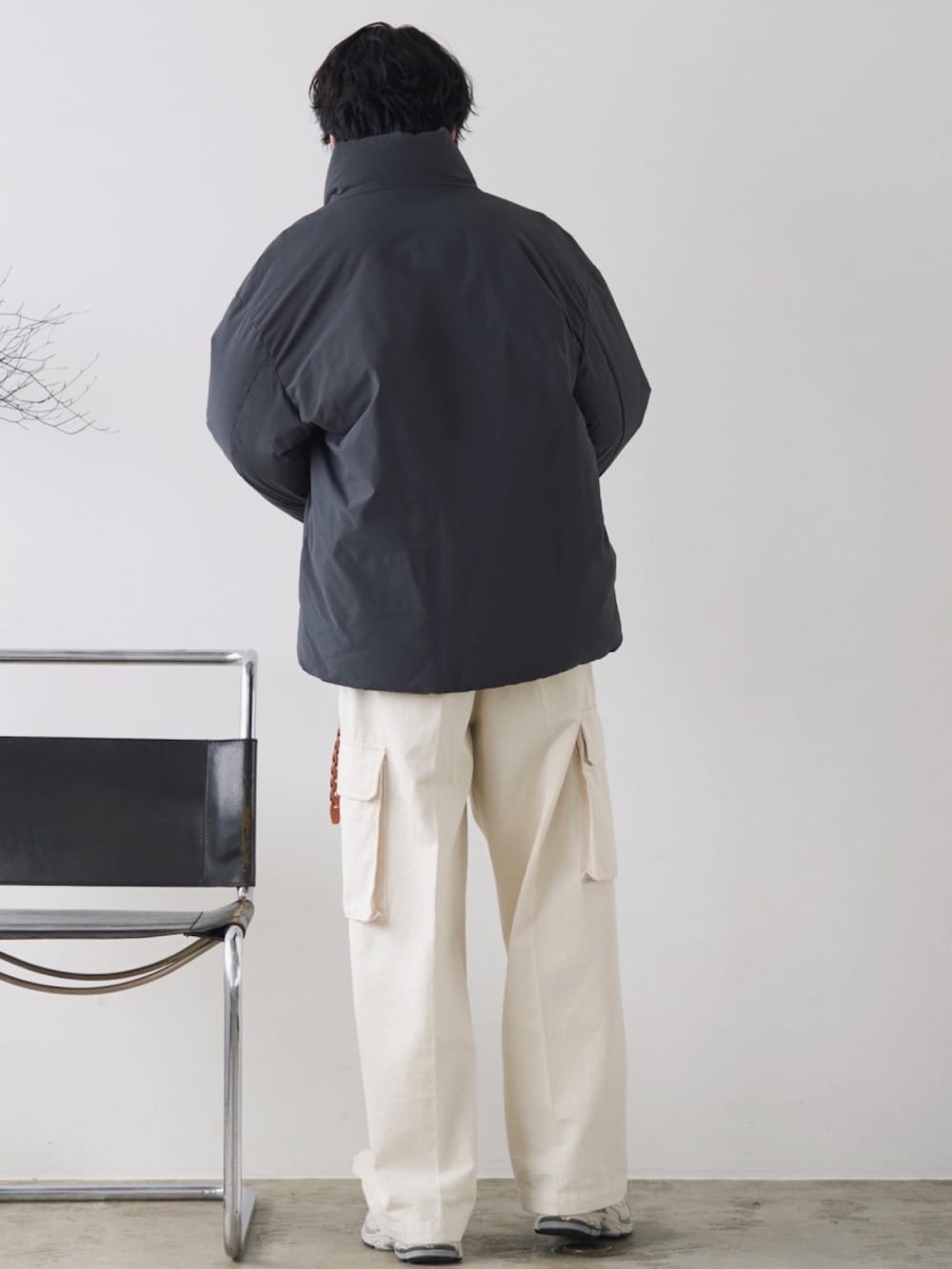 グレー系のダウンジャケット/コート、グレー系のニット/セーター、ホワイト系のカーゴパンツを着用したメンズの冬コーディネートの3枚目の写真