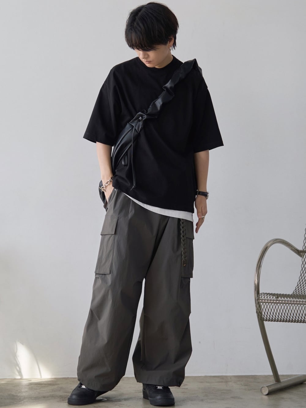 グレー系のベスト、ブラック系のTシャツ/カットソー、ホワイト系のタンクトップを着用したメンズの春コーディネートの2枚目の写真