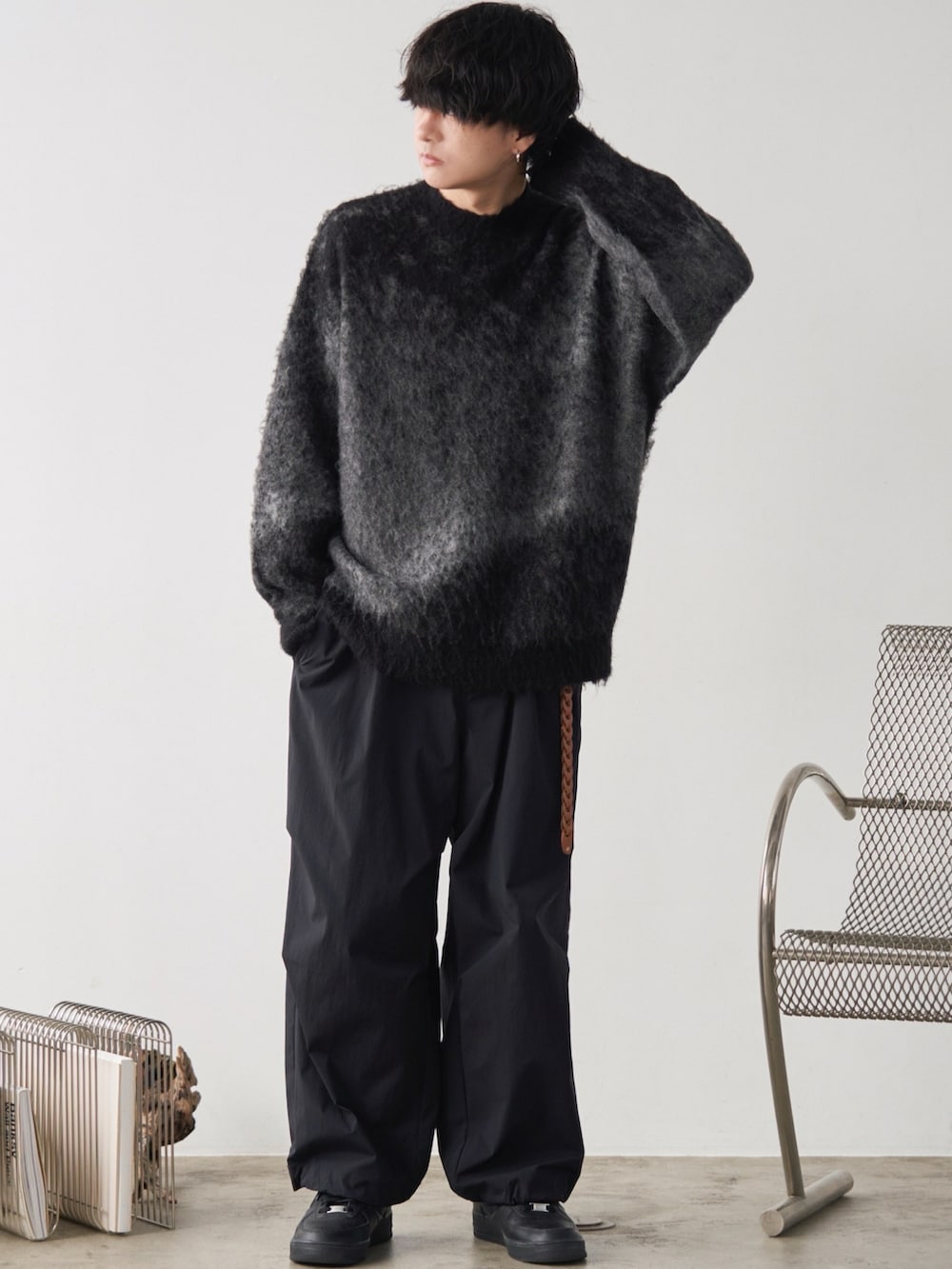 グレー系のチェスターコート、グレー系のニット/セーター、ブラック系のその他パンツを着用したメンズの冬コーディネートの3枚目の写真