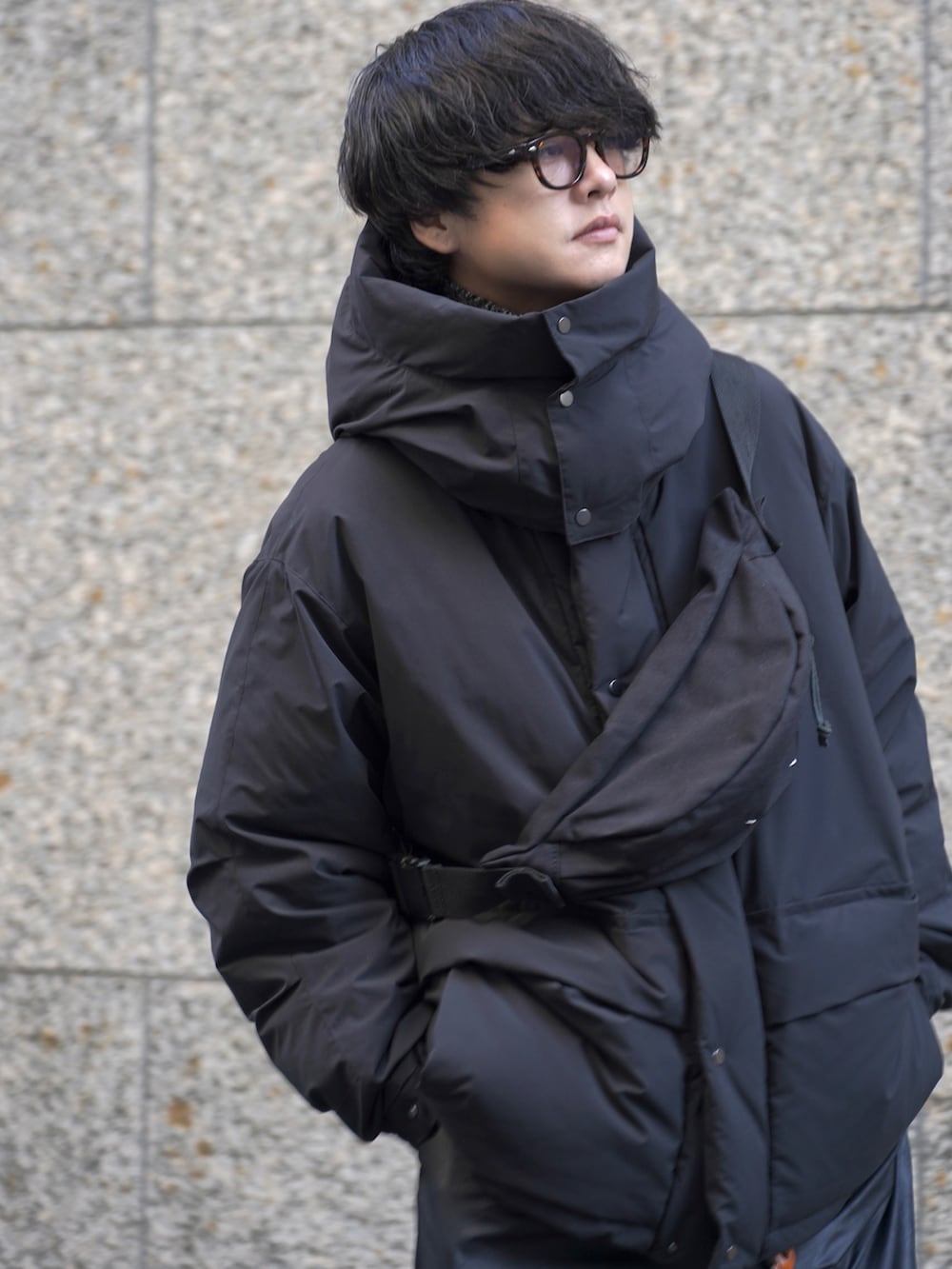 ブラック系のダウンジャケット/コート、ブラック系のその他パンツ、ブラック系のボディバッグ/ウエストポーチを着用したメンズの秋コーディネートの5枚目の写真