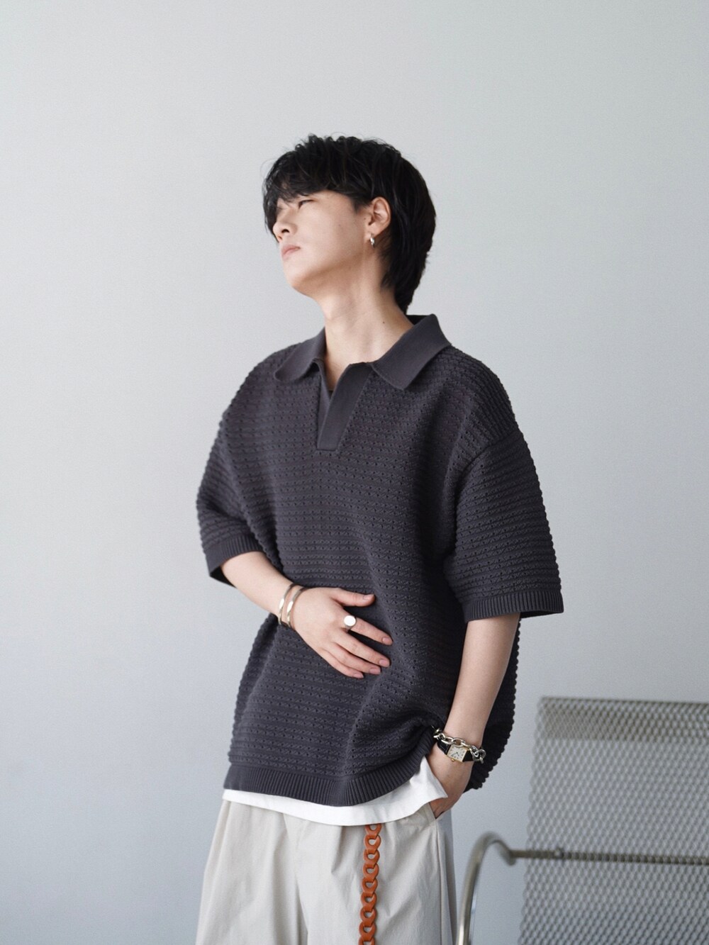 グレー系のポロシャツ、ホワイト系のタンクトップ、グレー系のその他パンツを着用したメンズの夏コーディネートの2枚目の写真