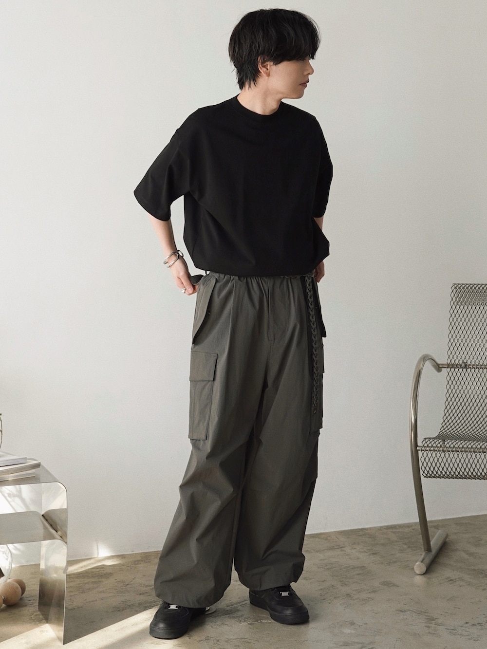 グレー系のベスト、ブラック系のTシャツ/カットソー、ホワイト系のタンクトップを着用したメンズの春コーディネートの5枚目の写真