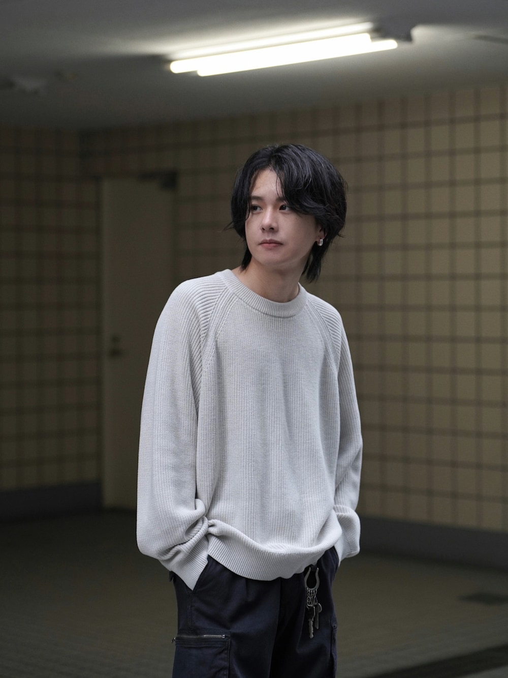 ホワイト系のニット/セーター、ブラック系のカーゴパンツ、グレー系のブルゾンを着用したメンズの秋コーディネートの4枚目の写真