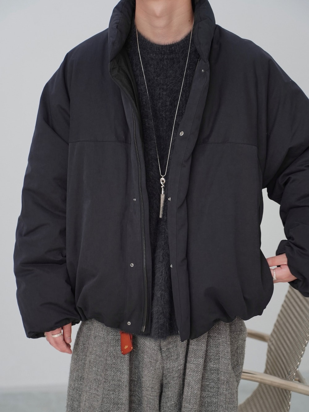 ブラック系のダウンジャケット/コート、ブラック系のニット/セーター、グレー系のその他パンツを着用したメンズの秋コーディネートの3枚目の写真