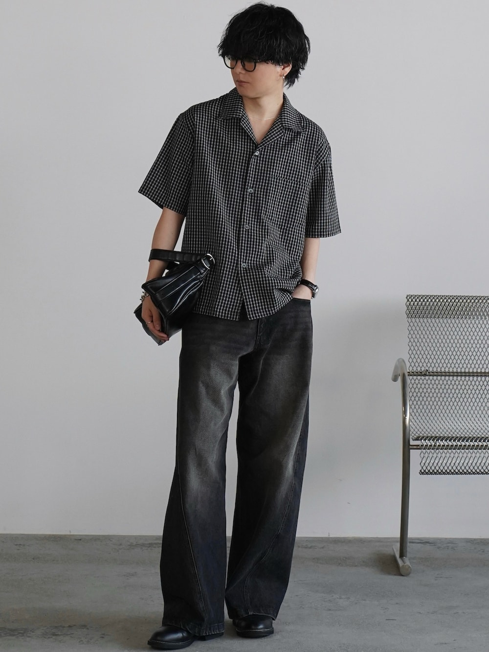 ブラック系のデニムパンツ、ブラック系のショルダーバッグ、ブラック系のドレスシューズを着用したメンズの春コーディネートの2枚目の写真