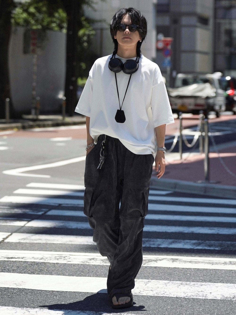 ホワイト系のTシャツ/カットソー、ブラック系のパンツ、ブラック系のサンダルを着用したメンズの夏コーディネートの3枚目の写真