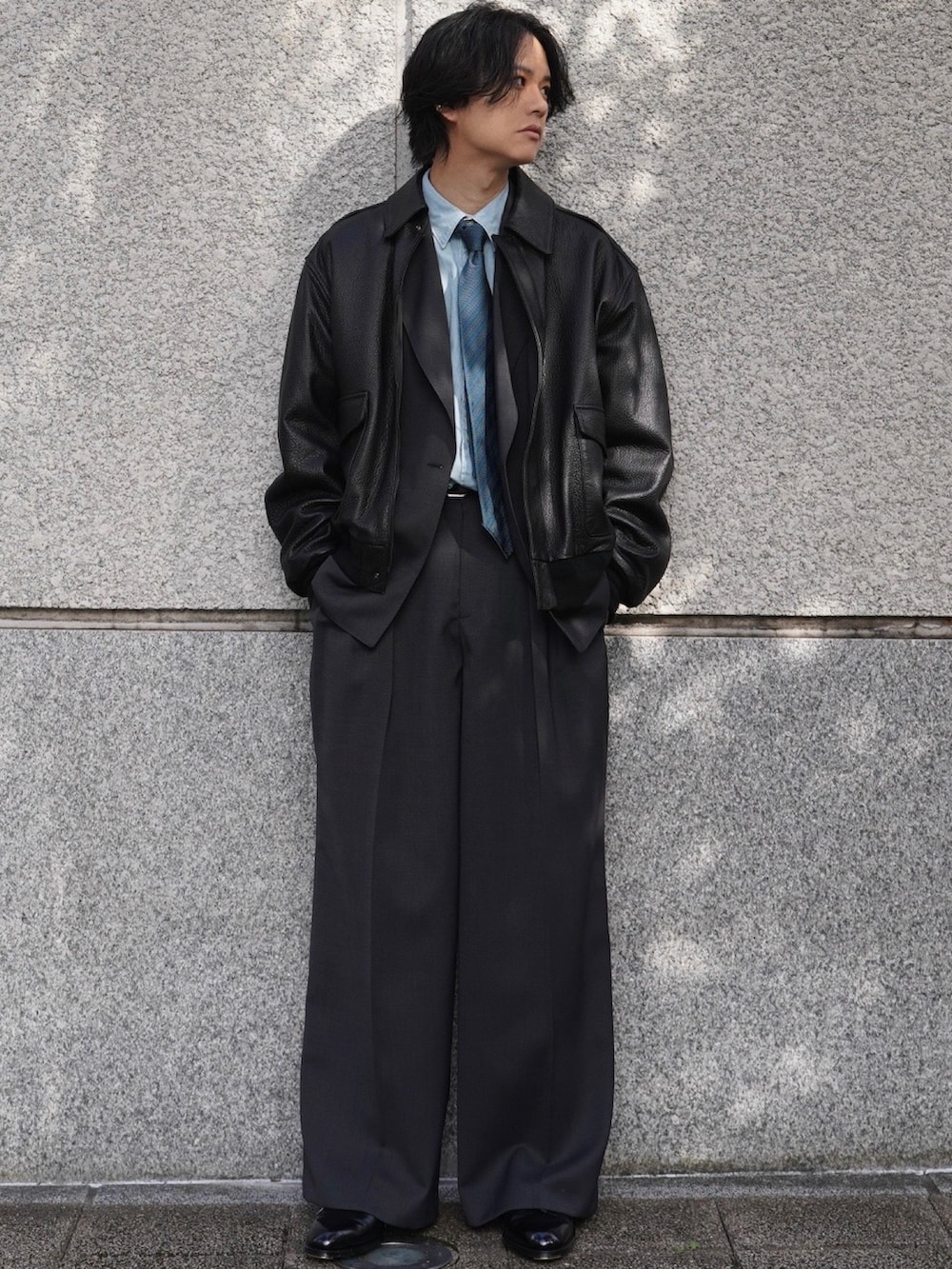 グレー系のテーラードジャケット、グレー系のスラックス、シルバー系のピアス(両耳用)を着用したメンズの冬コーディネートの2枚目の写真