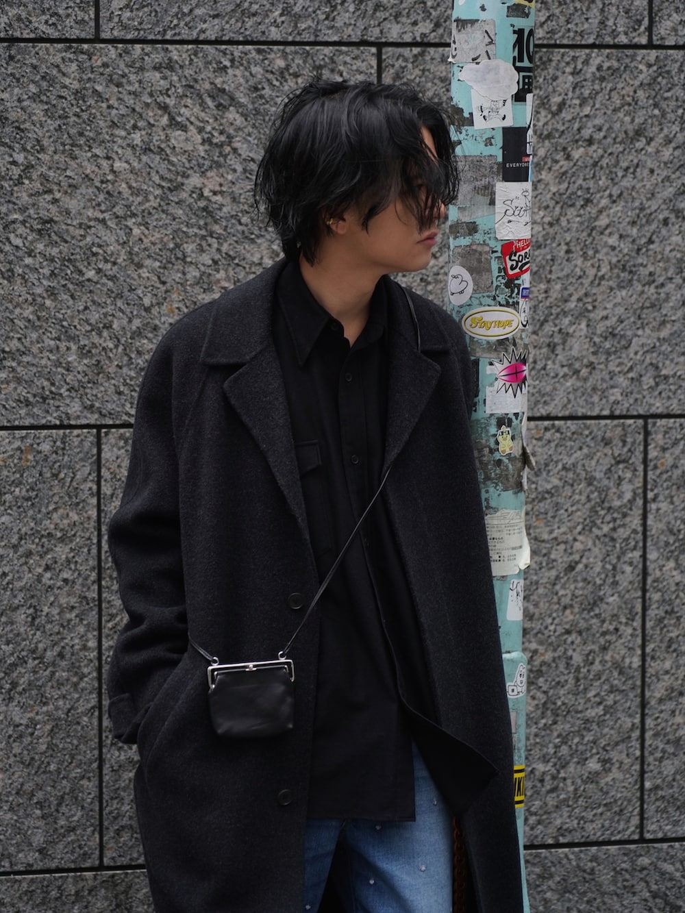 ブラック系のチェスターコート、ブラウン系のシャツ/ブラウス、ブルー系のパンツを着用したメンズの冬コーディネートの4枚目の写真