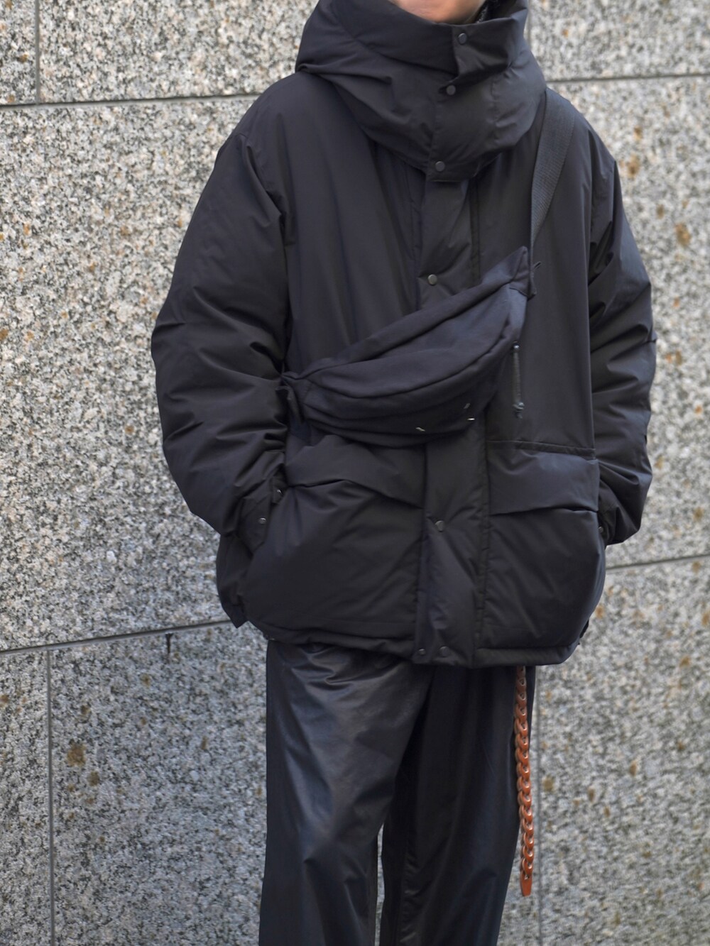 ブラック系のダウンジャケット/コート、ブラック系のその他パンツ、ブラック系のボディバッグ/ウエストポーチを着用したメンズの秋コーディネートの3枚目の写真