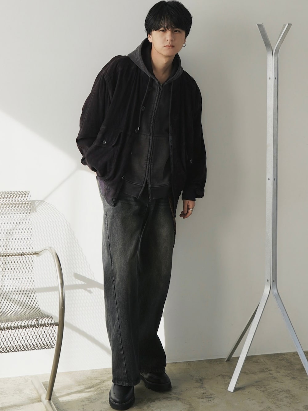 ブラウン系のパーカー、ブルー系のデニムパンツ、ブラック系のドレスシューズを着用したメンズの冬コーディネートの2枚目の写真