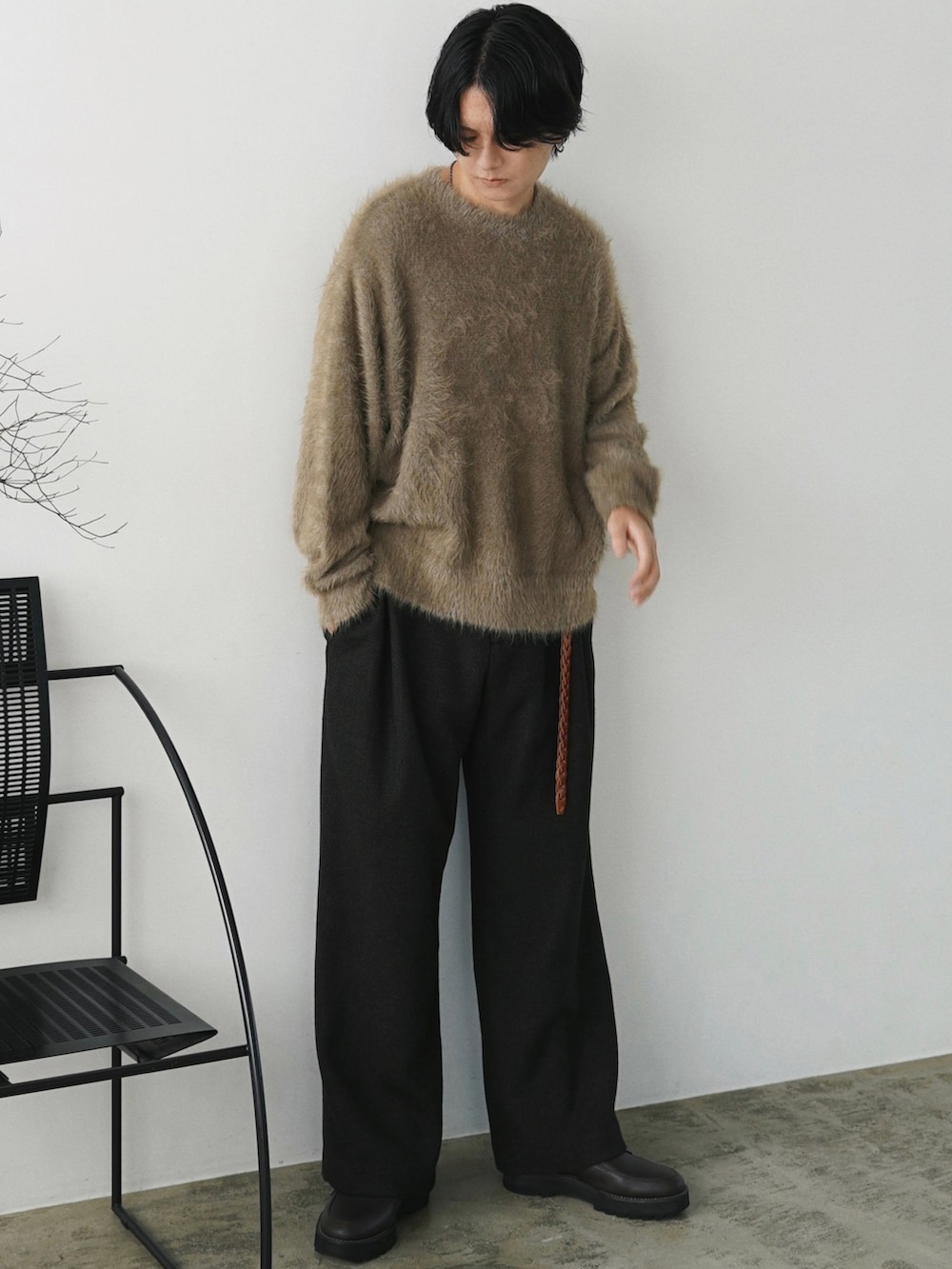 グリーン系のダウンジャケット/コート、グリーン系のニット/セーター、グレー系のスラックスを着用したメンズの秋コーディネートの3枚目の写真